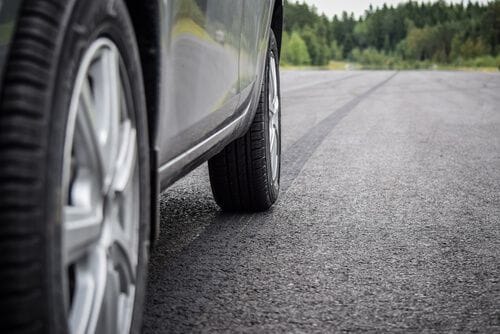 A Close up Photo of a Side of a car with two wheels