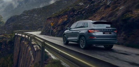 Grey Škoda Kodiaq SUV driving in misty hills