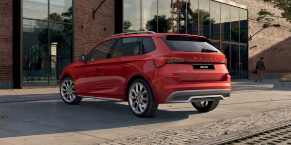 Rear three-quarter view of a red Skoda Kamiq parked on a modern urban street